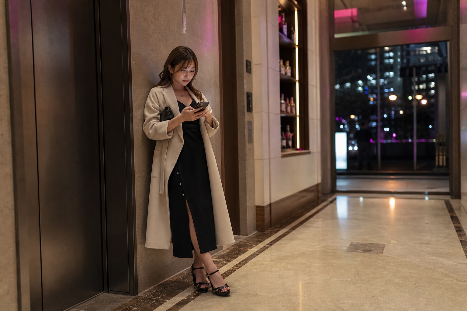 出勤前にエレベーターホールでLINEを送る成人女性